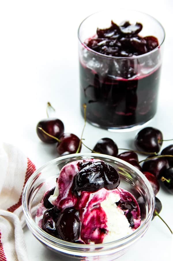 With 4 ingredients this Easy Cherry Compote is the best topping for putting on ice cream, pound cake, or even granola! Perfectly made with fresh cherries! Easy Cherry Compote in glass bowl with ice cream and fresh cherries in background