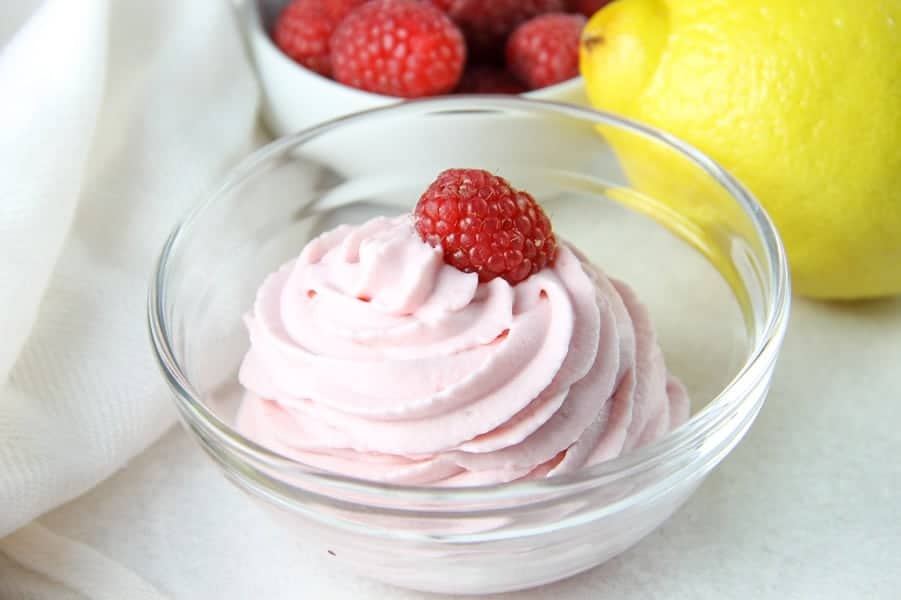 Easy 4 ingredient Lemon Raspberry Whipped Cream! A sweet homemade whipped cream filled with lemon and raspberry flavors! Perfect for topping on any dessert! Lemon Raspberry Whipped Cream in glass bowl topped with fresh raspberry