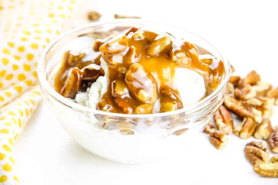 Easy Butter Pecan Sauce made with 6 ingredients! A creamy, gooey sauce filled with pecans and perfect topping for ice cream or any dessert! Butter Pecan Sauce in glass bowl over ice cream