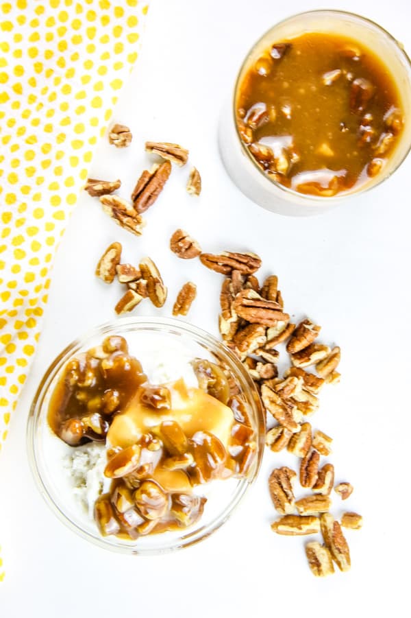 Easy Butter Pecan Sauce made with 6 ingredients! A creamy, gooey sauce filled with pecans and perfect topping for ice cream or any dessert! Butter Pecan Sauce overhead view of bowl with sauce over ice cream