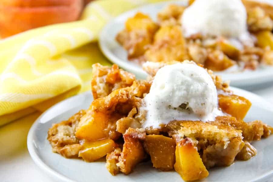 This Easy Peach Cobbler is filled with plump, fresh peaches with spices of cinnamon and brown sugar! Baked to perfection! Peach Cobbler on white plate