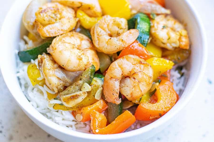 Easy Garlic Thyme Shrimp and Veggies! Cooks up in 10 minutes! This dish is loaded with lots of flavors and comes together in no time! Garlic Thyme Shrimp and Veggies in bowl with rice