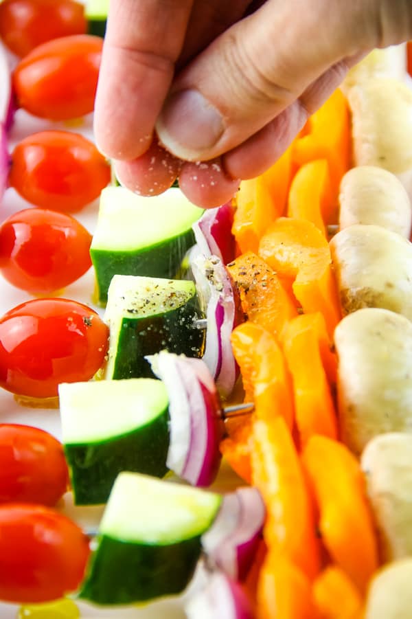 Easy Grilled Vegetable Skewers made with 5 different vegetables, flavored with salt, pepper and olive oil! Perfect for the grill or oven! Grilled Vegetable Skewers with hand sprinkling on salt and pepper