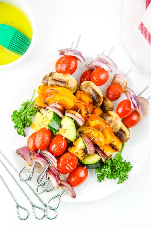 Easy Grilled Vegetable Skewers made with 5 different vegetables, flavored with salt, pepper and olive oil! Perfect for the grill or oven! Grilled Vegetable Skewers on white plate