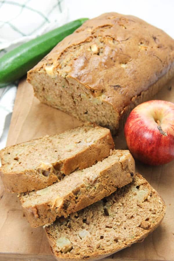 This Apple Zucchini Bread is perfectly moist! Loaded with apples and zucchini this bread is so flavorful! Perfect for breakfast or dessert! Apple Zucchini Bread on brown cutting board