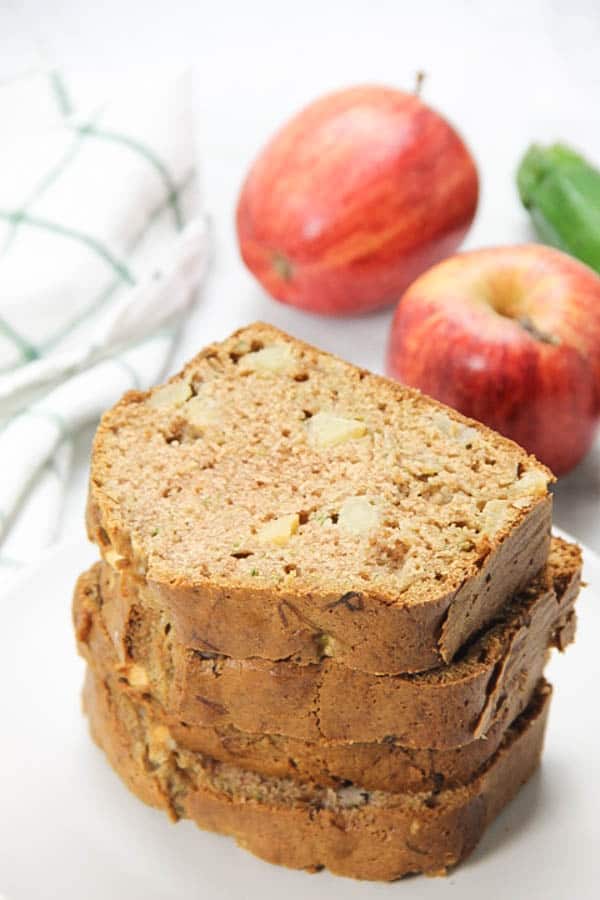 This Apple Zucchini Bread is perfectly moist! Loaded with apples and zucchini this bread is so flavorful! Perfect for breakfast or dessert! Apple Zucchini Bread slices stacked on top of each other
