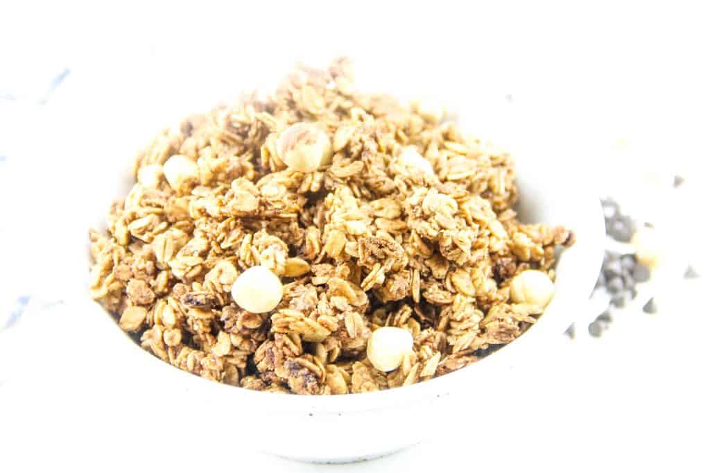This Chocolate Hazelnut Granola is perfect for snacking! Made with nutella, oats, maple syrup and canola oil! Simple and easy! Chocolate Hazelnut Granola in white bowl
