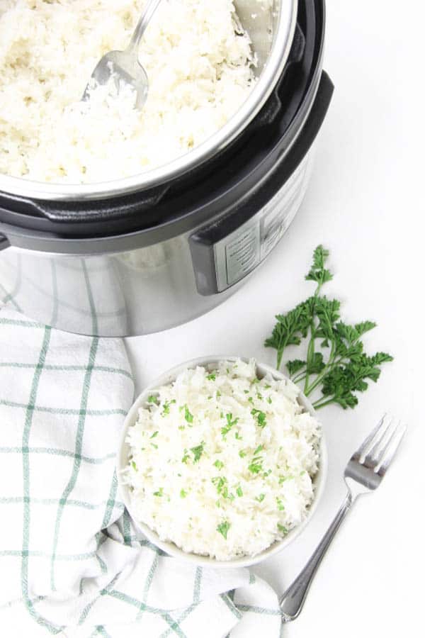 The EASIEST side dish to make! This Instant Pot Basmati Rice will be one that you make over and over again! Instant Pot Basmati Rice in white bowl with fork