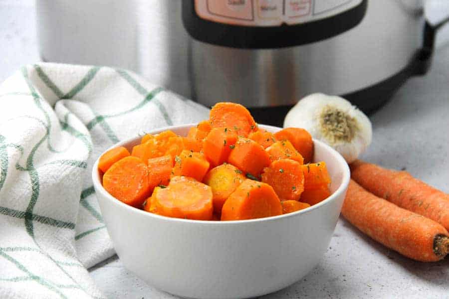These Instant Pot Carrots are the easiest side dish! With just 5 ingredients and 6 minutes cook time, these come together quickly! Instant Pot Carrots in gray bowl with green and white napkin