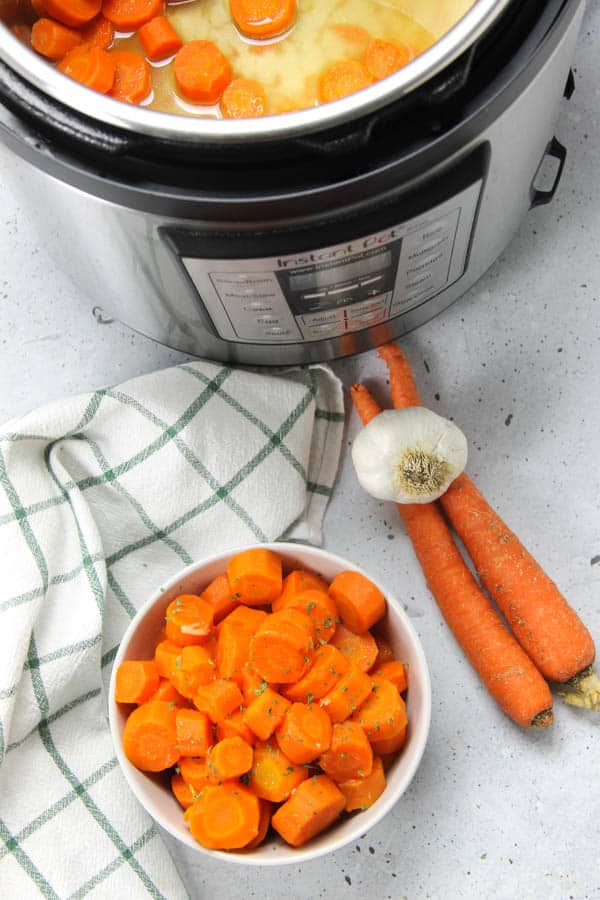 These Instant Pot Carrots are the easiest side dish! With just 5 ingredients and 6 minutes cook time, these come together quickly! Instant Pot Carrots overhead view in bowl and in instant pot