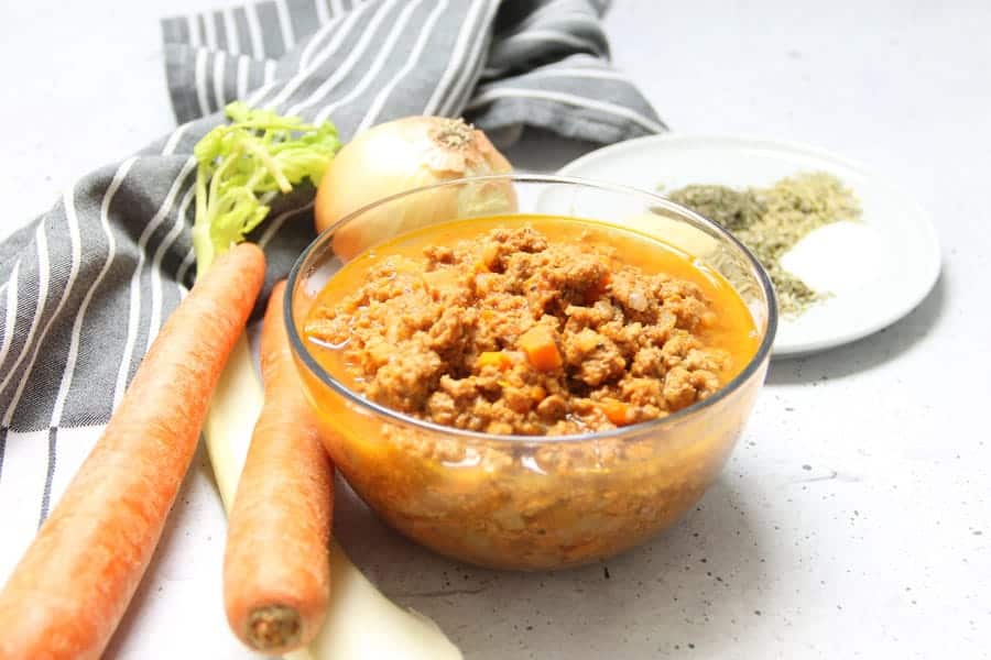 Easy Instant Pot Turkey Ragù! Made with ground turkey, herbs and tomato sauce this pasta sauce comes together quickly with the instant pot! Instant Pot Turkey Ragu in glass bowl with ingredients in background