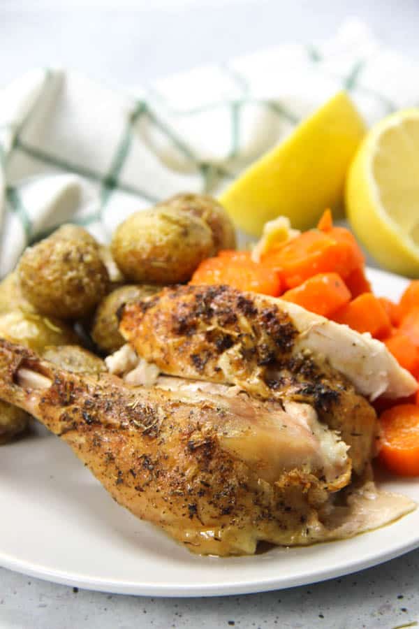 This Oven Baked Whole Chicken is cooked up perfectly with lemon, garlic and herbs. Tender, moist and lemony chicken for dinner!