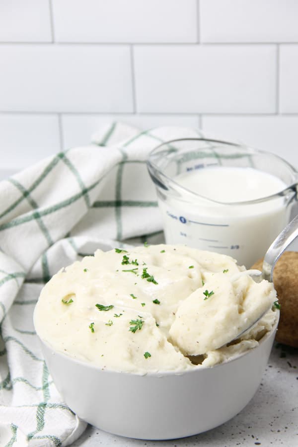 Pressure Cooker Mashed Potatoes with Gravy is an easy side dish! With creamy potatoes and a white gravy, it's ready in no time! Pressure Cooker Potatoes with Gravy in bowl with spoon