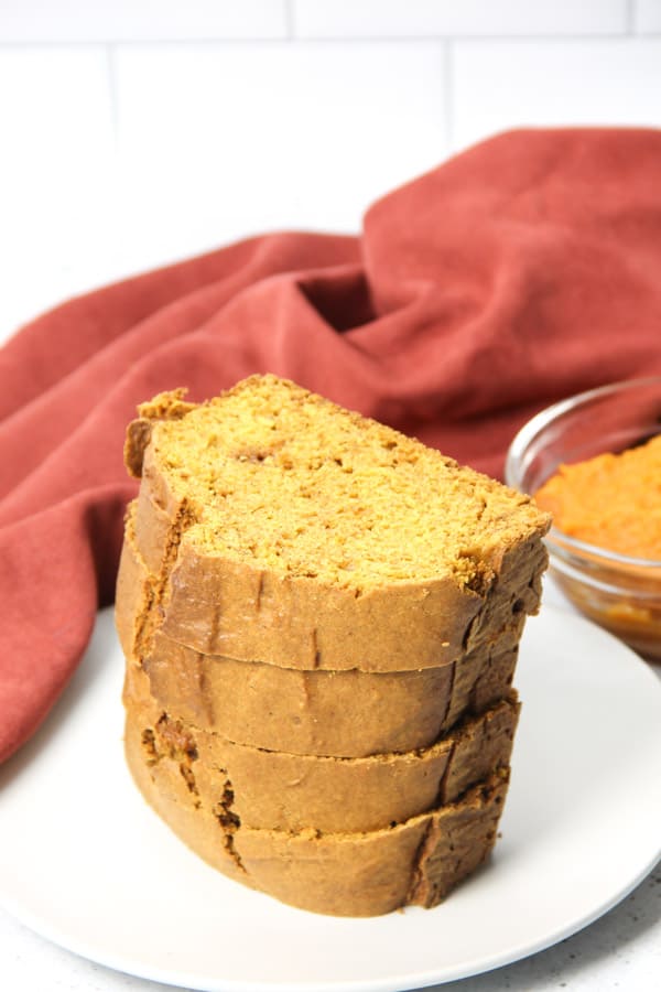This Easy Pumpkin Bread is the perfect moist, quick bread! It's made with canned pumpkin, cinnamon, ginger and nutmeg! Pumpkin Bread on white plate