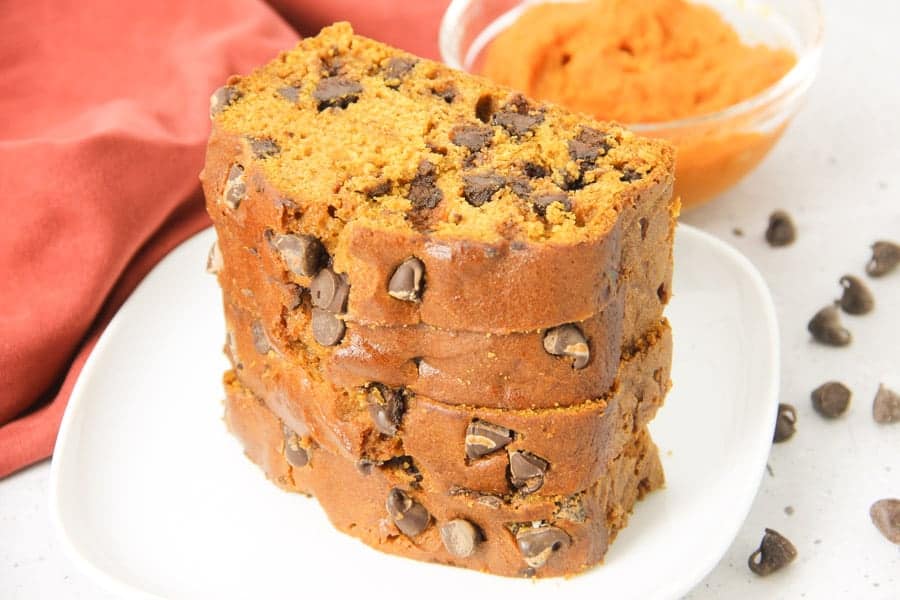 Delicious and easy Chocolate Chip Pumpkin Bread! Moist and tender, this bread is filled with warm spices and rich chocolate! Chocolate Chip Pumpkin Bread on white plate
