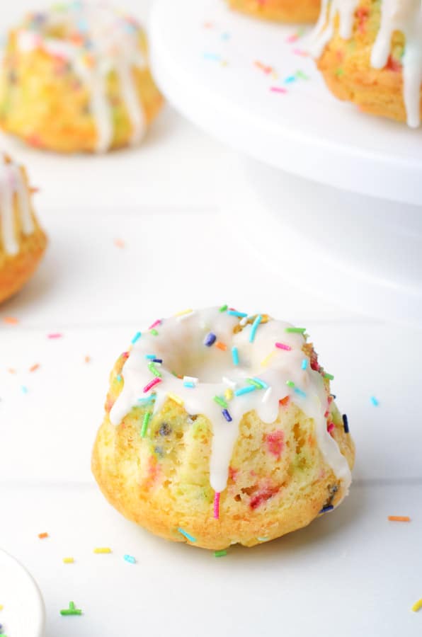 These homemade Funfetti Mini Bundt Cakes are perfect for any celebration! Made with simple ingredients and lots of sprinkles! Funfetti Mini Bundt Cakes single cake on white background