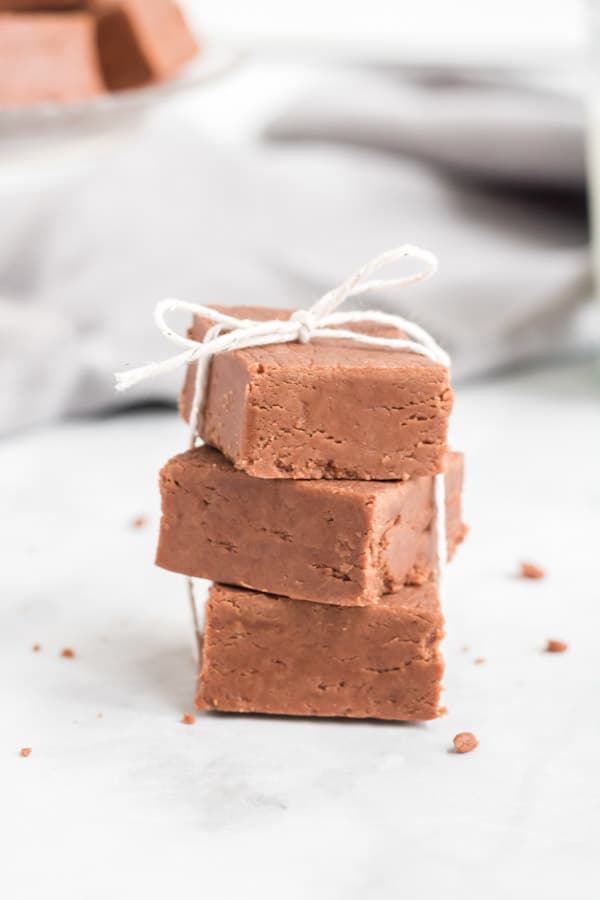 Creamy and Easy Fantasy Fudge! Made with just 6 ingredients and is nut free! Perfect candy for all occasions! Fudge stacked on white background