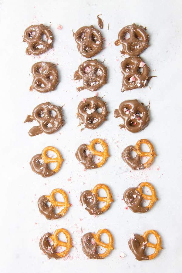 These Peppermint Chocolate Dipped Pretzels are an easy last minute treat! A delicious sweet and salty snack! Pretzels covered in chocolate laid out on parchment paper
