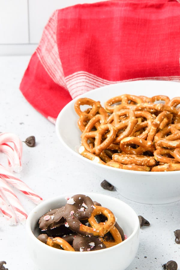 These Peppermint Chocolate Dipped Pretzels are an easy last minute treat! A delicious sweet and salty snack! Peppermint Chocolate Dipped Pretzels in white bowl