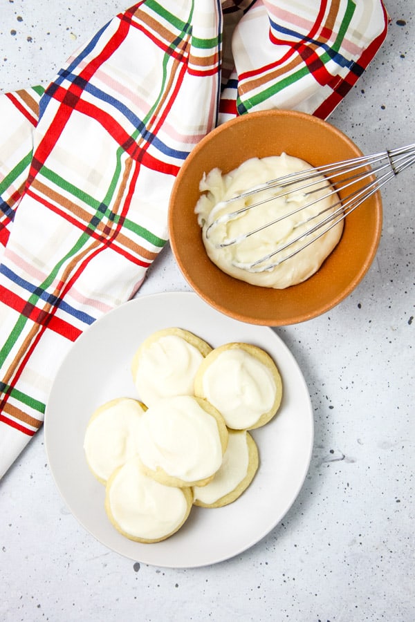 These classic Soft Sugar Cookies are perfect for a baking day! With a buttercream frosting and fun sprinkles they will be a hit! Soft Sugar Cookies without sprinkles on white plate
