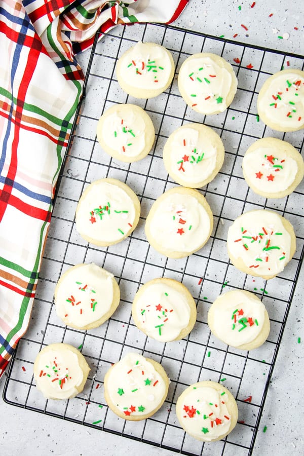 These classic Soft Sugar Cookies are perfect for a baking day! With a buttercream frosting and fun sprinkles they will be a hit! Soft Sugar Cookies on black cookie rack