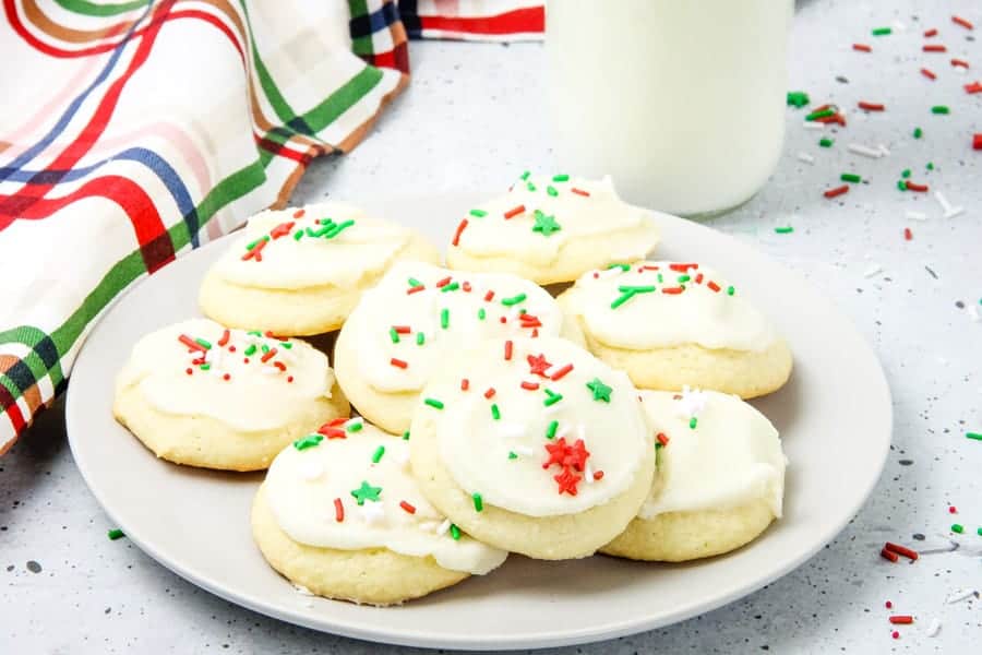 These classic Soft Sugar Cookies are perfect for a baking day! With a buttercream frosting and fun sprinkles they will be a hit! Decorated cookies on a plate