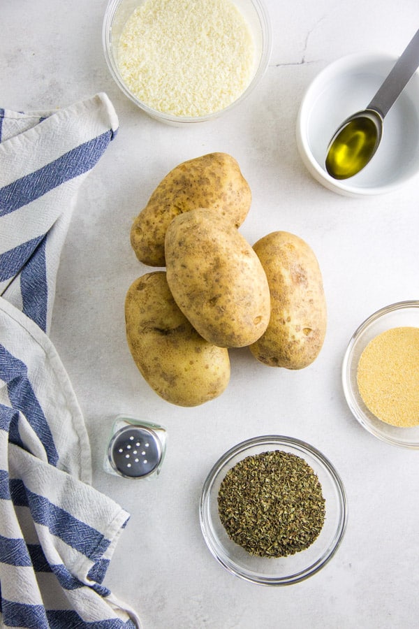 These easy to make Air Fryer Parmesan Potato Wedges cook up in just 20 minutes! Topped with flavors of basil, garlic and cheese! Air Fryer Parmesan Potato Wedges ingredients in bowls.
