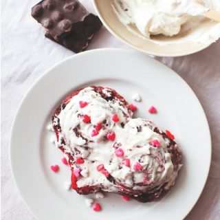 Red Velvet Cinnamon Rolls on plate with sprinkles