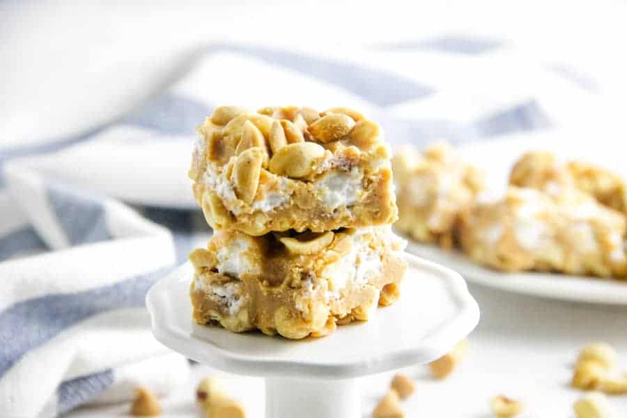 Salted Nut Roll Bars are a candy classic made into a delicious ooey gooey bar! Filled with peanut butter and marshmallows, the whole family would enjoy it! close up of salted nut roll bars on stand