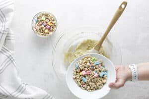 adding cereal to cookie dough.