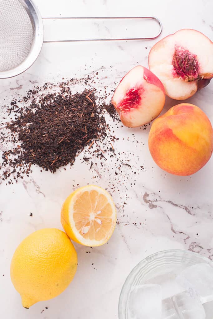 Ingredients for Peach Black Tea Lemonade on white background.