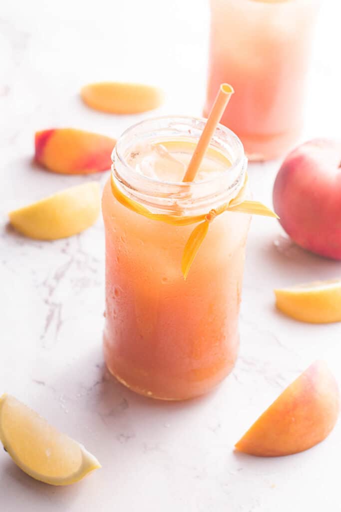 This simple, refreshing Peach Black Tea Lemonade has the perfect blend of flavors and just a touch of sweetness! Perfect for hot summer days! Peach Black Tea Lemonade in glass jar with straw.