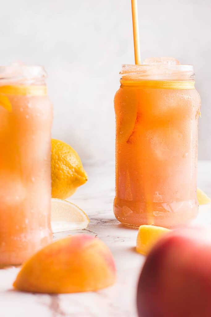 This simple, refreshing Peach Black Tea Lemonade has the perfect blend of flavors and just a touch of sweetness! Perfect for hot summer days! Peach Black Tea Lemonade in glass jars with straw.