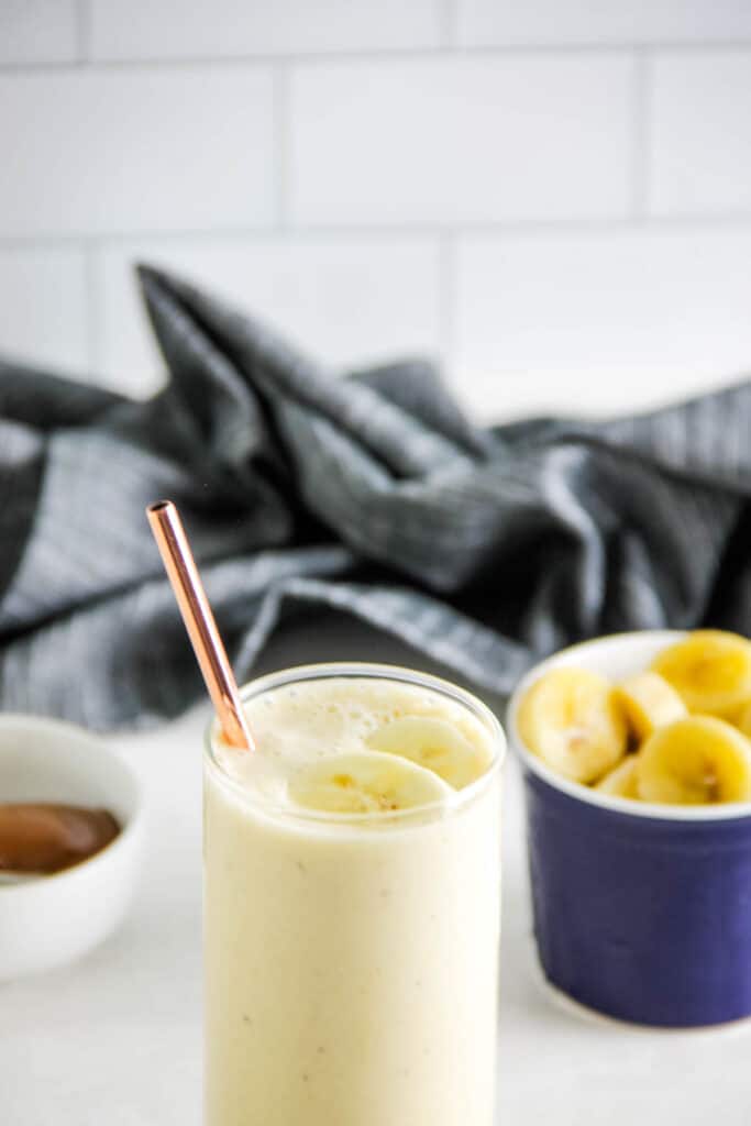 Banana Caramel Smoothie is fresh and creamy! Made with just 5 ingredient, this smoothie will help you power through the day! smoothie in glass with straw.