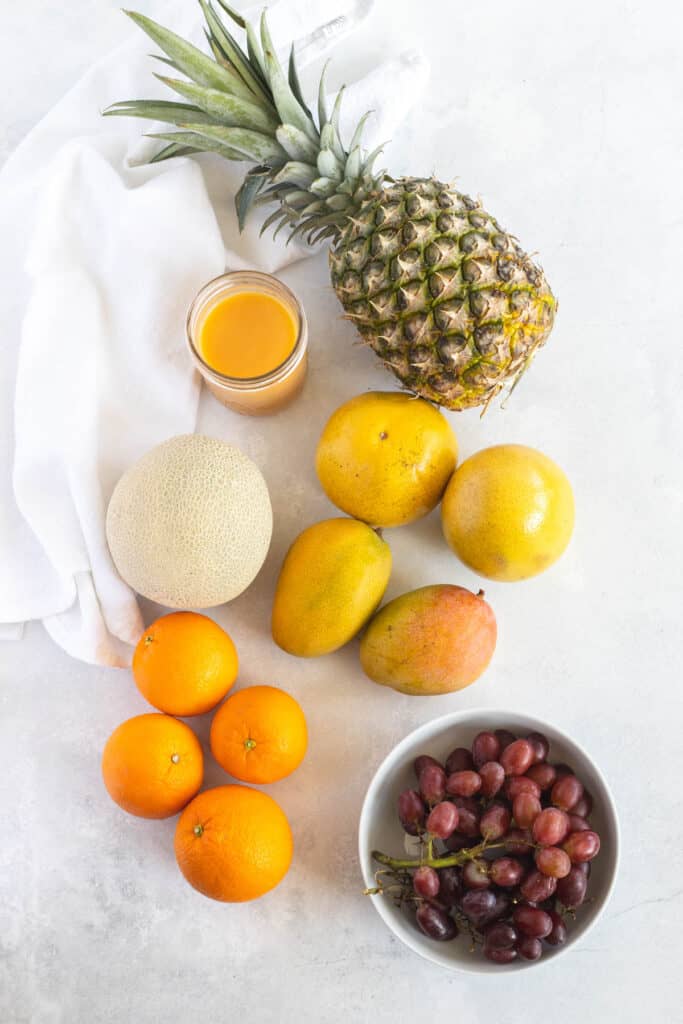 This Citrus Fruit Salad is so simple to put together! With seasonal fruit and a splash of orange juice this salad is long lasting! Citrus Fruit Salad ingredients on white background.