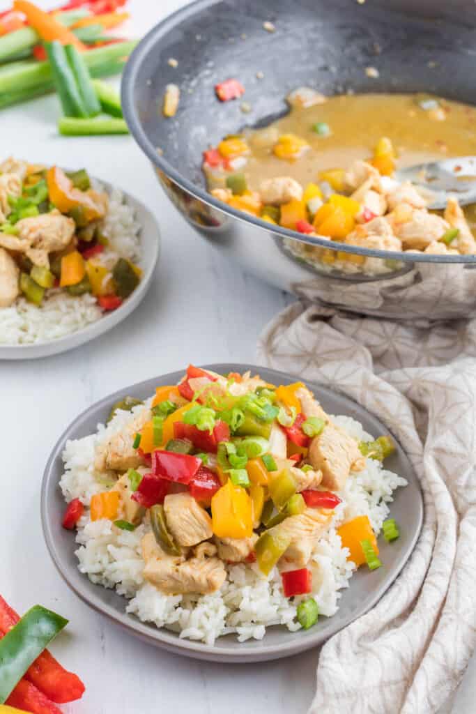 Italian Dressing Chicken Stir Fry takes very little time to make but is popping with lots of color and flavors that won't disappoint. stir fry on plate with pan in background.