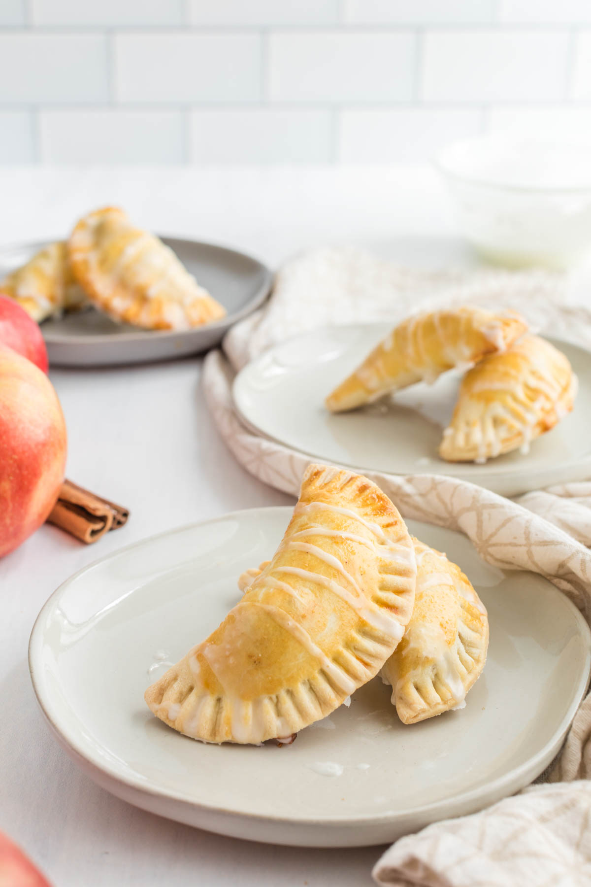 Homemade buttery pie crust filled with a delicious simple apple compote makes these Apple Pie Turnovers a new family favorite! Apple Pie Turnovers on white plate.