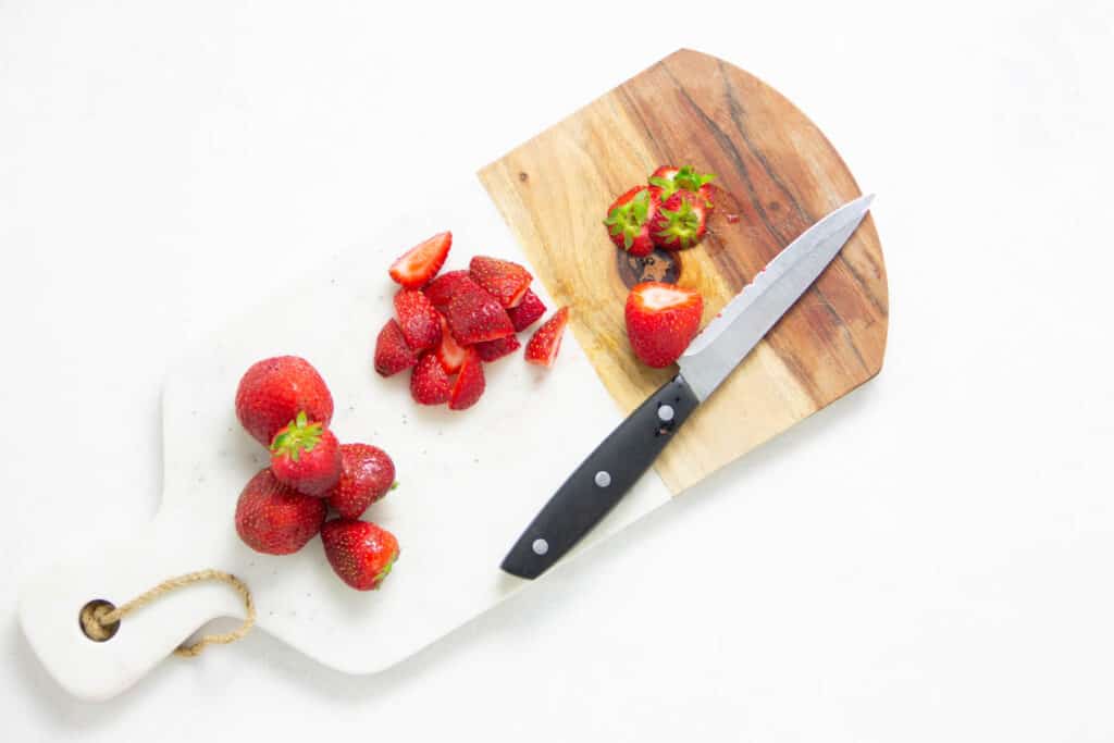cut up strawberries on cutting board.