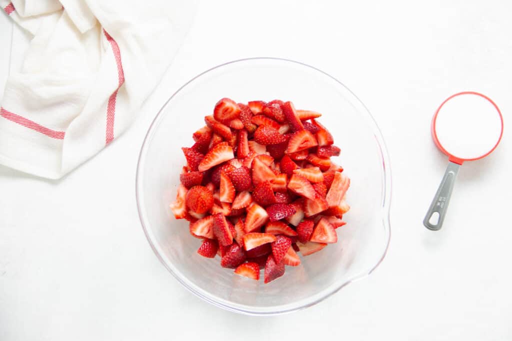 strawberries in glass bowl with sugar.