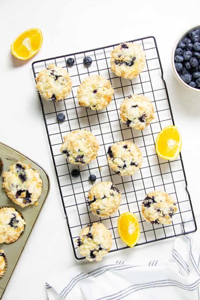 The best Orange Blueberry Muffins! So tender and moist, with a buttery crumb topping! Made with fresh blueberries and oranges! muffins on cooling rack.