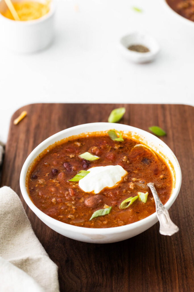 Easy Slow Cooker Chili with homemade seasoning and robust flavor! Packed with protein and perfect for a weeknight dinner! Slow Cooker Chili in bowl with spoon.