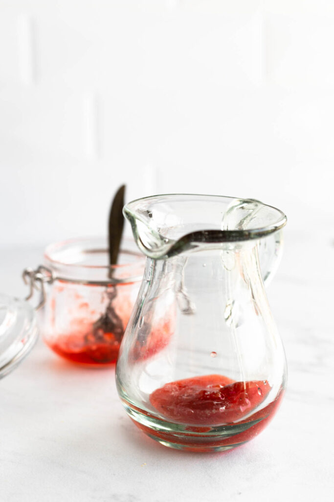 Easy homemade Strawberry Balsamic Vinaigrette! This easy dressing goes perfectly on any salad and it's customizable with any fruit jam! adding strawberry jam to glass pitcher.