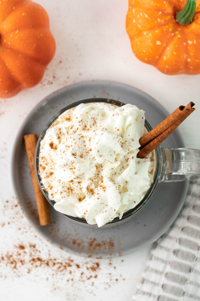 This Pumpkin Spice Latte taste just like the big chains! You can easily make it at home for the same great taste! Pumpkin Spice Latte overhead view topped whipped cream.