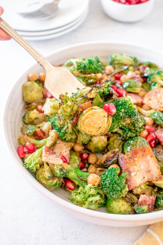 This Warm Brussels Sprouts Salad with Bacon, chickpeas and broccoli that is topped with an apple cider dijon dressing! Warm Brussels Sprouts Salad on fork.