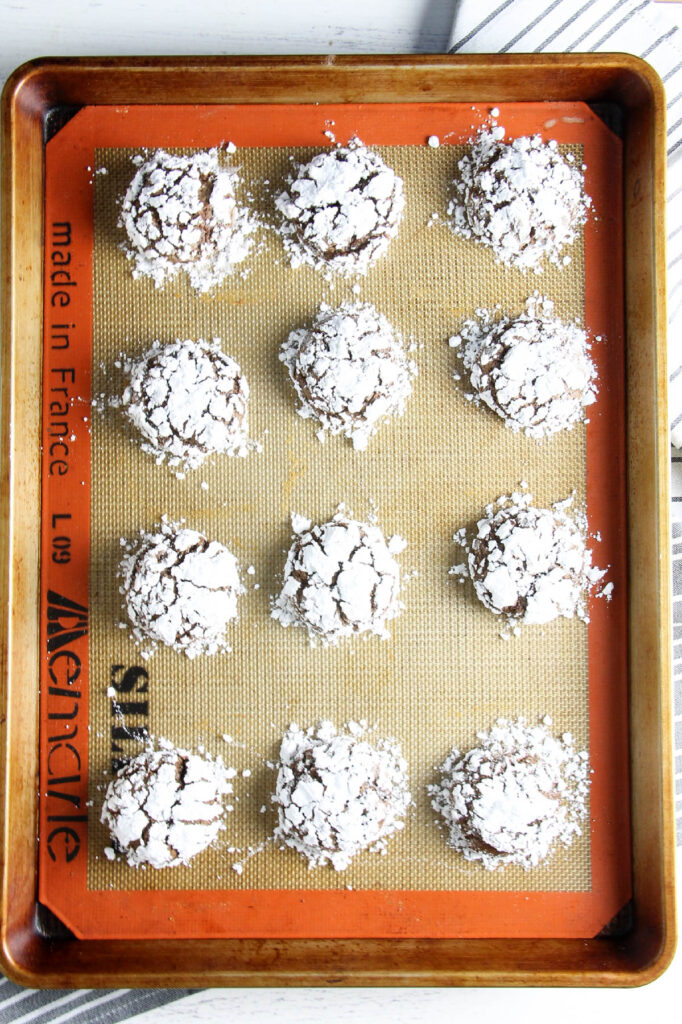 Chocolate Hazelnut Crinkle Cookies are impossible to resist. They're made with the sweet addition of creamy hazelnut spread! Chocolate Hazelnut Crinkle Cookies baked on tray.