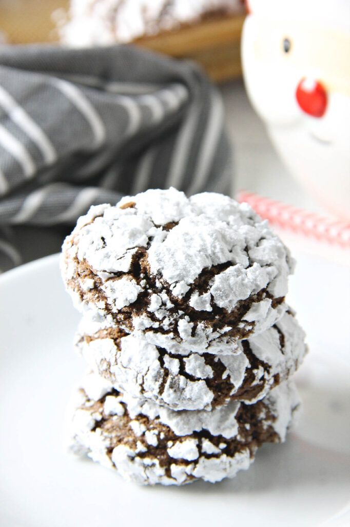 Chocolate Hazelnut Crinkle Cookies are impossible to resist. They're made with the sweet addition of creamy hazelnut spread! Chocolate Hazelnut Crinkle Cookies on white plate.