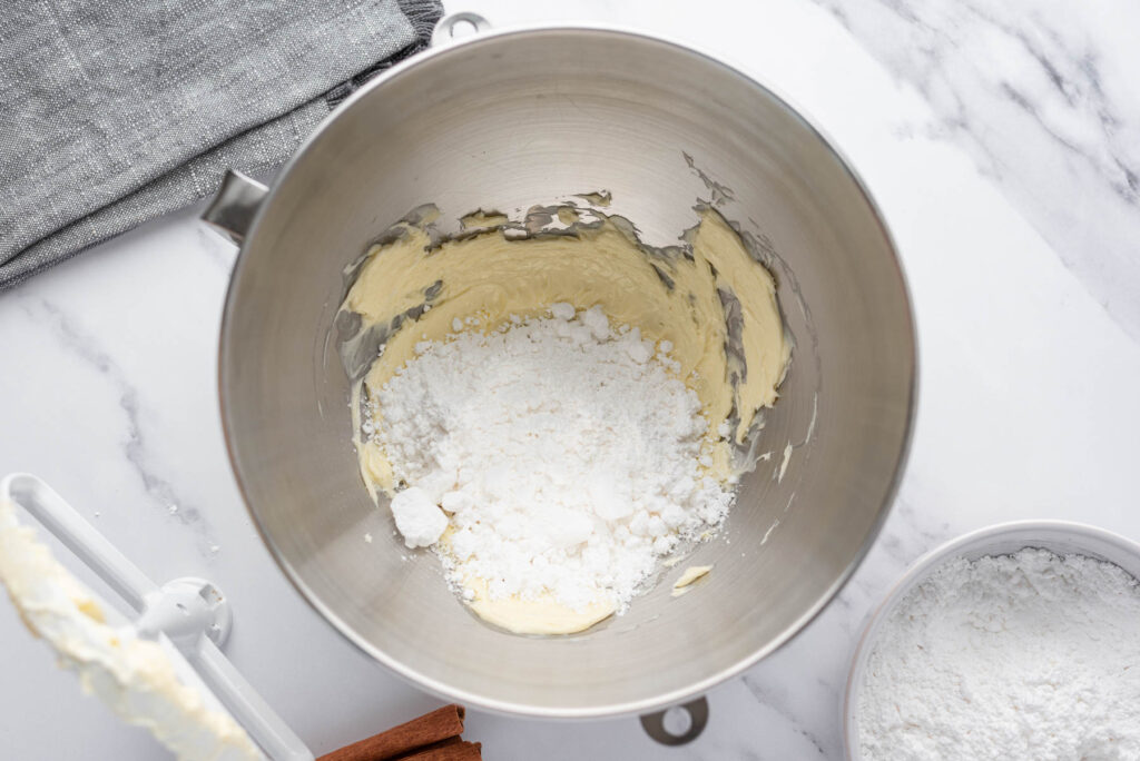 butter and powdered sugar in metal mixing bowl.