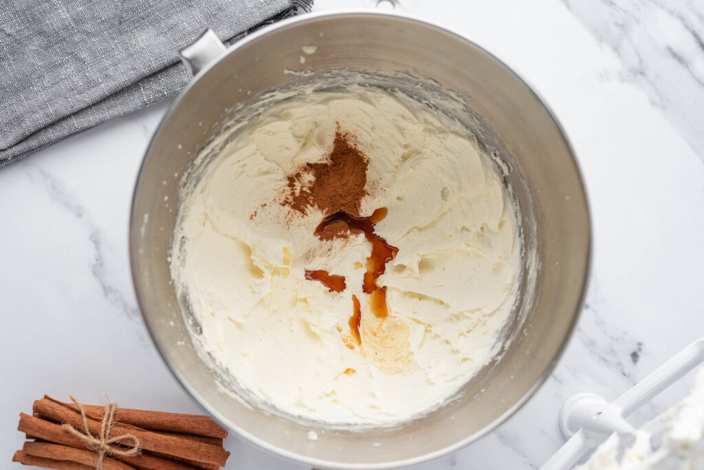buttercream mixed with cinnamon in metal mixing bowl.