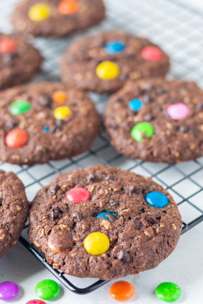 These Double Chocolate Monster Cookies have lots of texture with a little bit of crunch. Lots of mix-in options for the best cookie! Double Chocolate Monster Cookies on cookie rack.