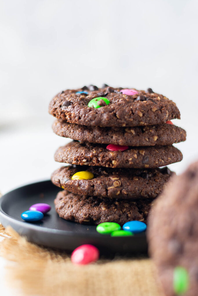 These Double Chocolate Monster Cookies have lots of texture with a little bit of crunch. Lots of mix-in options for the best cookie! Double Chocolate Monster Cookies stacked on top of each other.